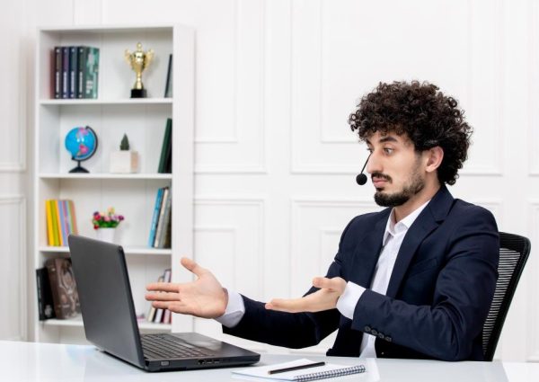 customer-service-handsome-curly-man-office-suit-with-computer-headset-waving-hands